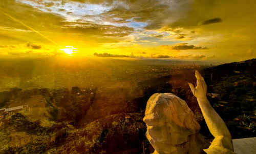 A breathtaking sunset view of the majestic Jesus statue at Cerro del Santisimo, capturing the serenity and magnificence of the moment.