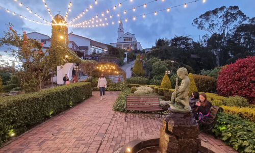 A captivating image showcasing the awe-inspiring sight of the Monserrate Church towering over the gardens in the early evening. This snapshot welcomes you to experience a world of grandeur, beauty, and tranquility.